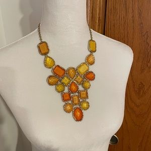 Gold tone bib necklace with yellow and orange hued stones